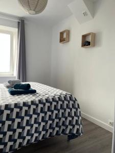 1 dormitorio con cama a cuadros en blanco y negro en APPARTEMENT CENTRE HISTORIQUE - Lannion, en Lannion