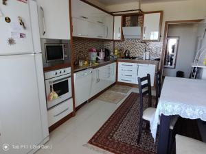 a kitchen with white appliances and a table and a table and a dining room at Rainfort apart Pınarkent 2+1 in Pamukkale