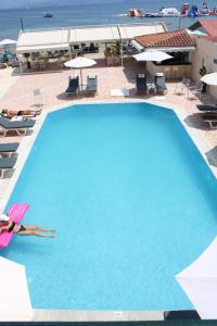 a woman laying on the side of a swimming pool at Stavros Beach Resort in Kavos