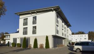 a white building with a car parked in front of it at Hotel Feyrer in Senden