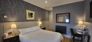 a hotel room with a white bed and a desk at White Horse Inn & Restaurant in Stoke Albany