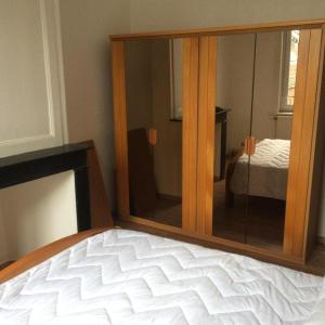 uno specchio sopra il letto in una camera da letto di HOMESTAY LILLE a Lille
