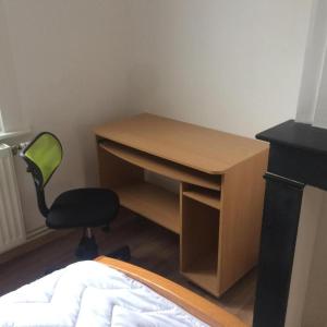 una scrivania e una sedia in una camera con un letto di HOMESTAY LILLE a Lille