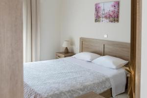 a bedroom with a white bed and a picture on the wall at Kostas 2 in Kos Town