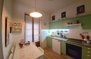 uma cozinha com armários verdes e uma mesa com cadeiras em La casa del mirador em Zamora