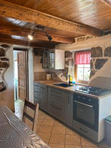 uma cozinha com um fogão e uma bancada em konoba em Rab