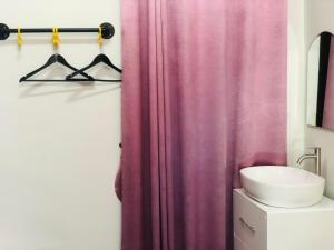 baño con cortina de ducha rosa y lavamanos en กอบสุข รีสอร์ท2 k04, en Ban Ton Liang