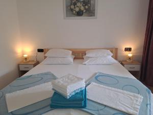 a bedroom with a bed with towels on it at Studio Apartments Maslinik in Krk