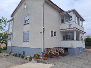 een gebouw met potplanten ervoor bij Studio Apartments Maslinik in Krk +39 foto's