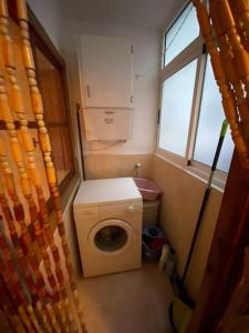 a small bathroom with a washing machine and a window at RIU MAR Apartment Cullera in Cullera