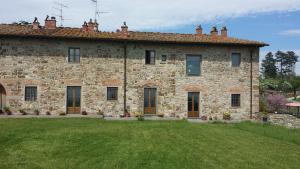 uma grande casa de pedra com um quintal em frente em Casa Adrigagi Firenze e La Via degli Dei em Pratolino