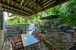 eine Terrasse mit einem Tisch, Stühlen und einem Sonnenschirm in der Unterkunft Rogalida in Lambiní