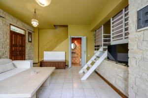 ein Wohnzimmer mit Fernseher und Treppe in der Unterkunft Rogalida in Lambiní