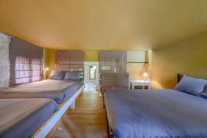 ein Schlafzimmer mit zwei Betten und einem Tisch mit Lampe in der Unterkunft Rogalida in Lambiní