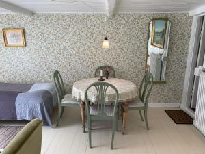 a dining room with a table and chairs and a bed at Farm61 badehotellet i det midtjydske - alder +18 år in Tjele