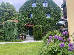 an ivy covered building with a door and some flowers at Apartment Thomabauerhof in Oberzeiring