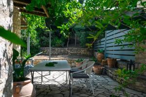 un patio con mesa y sillas en un jardín en Kandinella, en Lambiní