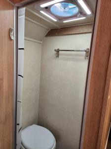 a small bathroom with a toilet and a ceiling at Muscat Caravans in Barka
