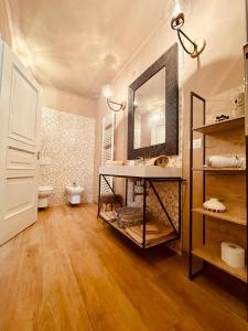 a bathroom with a sink and a toilet and a mirror at Suite Villa Aurelj in Barolo