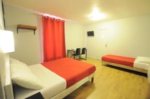 A bed or beds in a room at Hipotel Paris Gambetta République
