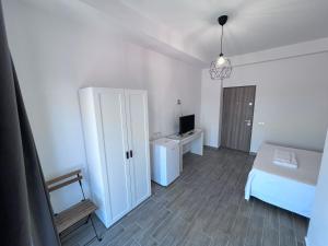 Schlafzimmer mit einem Bett, einem TV und einer Tür in der Unterkunft BSA in Eforie Sud