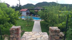 a backyard with a swimming pool and a house at Rustic Village House 4 in Rijeka Crnojevića