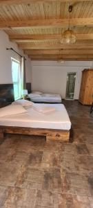 Vita de vie estival في كوستينيشت: سريرين في غرفة نوم ذات سقف خشبي