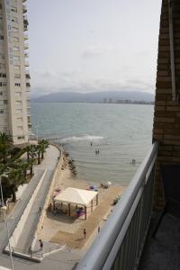 a view of the beach from the balcony of a building at Mediterraneo in Faro de Cullera