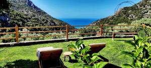 un patio con 2 sillas y vistas al océano en Casa Diosa, en Palaiochóra