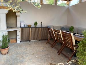 patio z krzesłami, stołem i kanapą w obiekcie Apartmani Perić w mieście Stari Grad