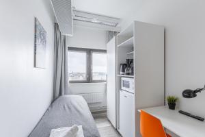 a small bedroom with a bed and a desk at Sky Hostel Helsinki in Helsinki