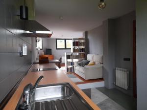 a kitchen with a sink and a living room at Chalet en Quintueles afueras de Gijón Asturias in Quintueles