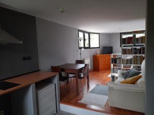 uma cozinha e sala de estar com uma mesa e um sofá em Chalet en Quintueles afueras de Gijón Asturias em Quintueles