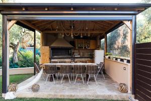 an outdoor kitchen with a table and chairs at Villa Nous luxury in Skala Sotiros