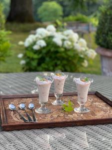 um tabuleiro com quatro bebidas numa mesa com colheres em Chateau Pont Jarno B&B em Champdeniers