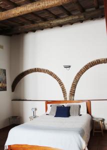 een slaapkamer met een groot bed met een houten hoofdeinde bij Casa Refúgio in Évora