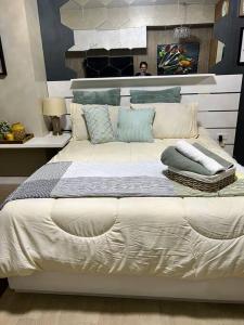 ein großes weißes Bett mit Kissen darüber in der Unterkunft Luxury Suite in Araneta in Manila