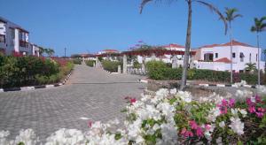 a cobblestone street with flowers and houses and palm trees at The hayce residence in Kilifi