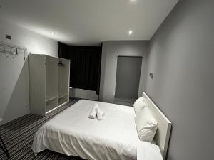 a bedroom with a bed with white shoes on it at 339 High Town Road in Luton