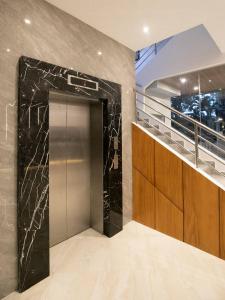 un ascensor en un edificio con una pared de mármol negro en City Pod Hotel, en Cebú