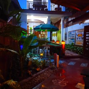 a restaurant with a patio with an umbrella and plants at MilVir Tourist INN in El Nido