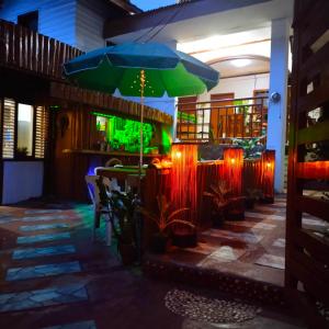a restaurant with a table with a green umbrella at MilVir Tourist INN in El Nido