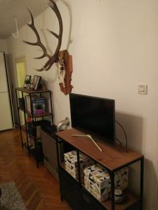 a living room with a tv and a desk with a television at Cozy Apartment near tram station in Zagreb