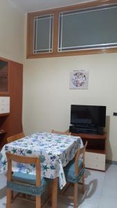 ein Esszimmer mit einem Tisch und einem TV in der Unterkunft Civico 32 in Molfetta