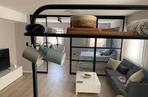 a living room with a loft bed and a couch at Espectacular loft lleno de luz y espacio! in Zaragoza