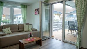 a living room with a couch and a table with wine glasses at BK Appartement in Balatonfüred