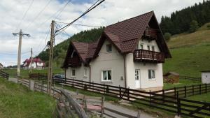 una casa bianca con tetto marrone e recinzione di Casa Caprioara a Fundata