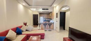 een woonkamer met een rode bank en een keuken bij Buki-Gravity-Homes, App No1, amazing spacy beachfront apartment in 5 star hotel Gravity Sahl Hasheesh- FOR GUESTS WITH NONEGYPTIAN PASSPORTS in Hurghada