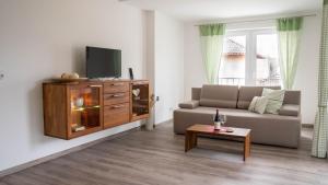 a living room with a couch and a tv at BK Appartement in Balatonfüred