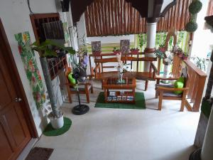 a living room with chairs and tables and plants at MilVir Tourist INN in El Nido